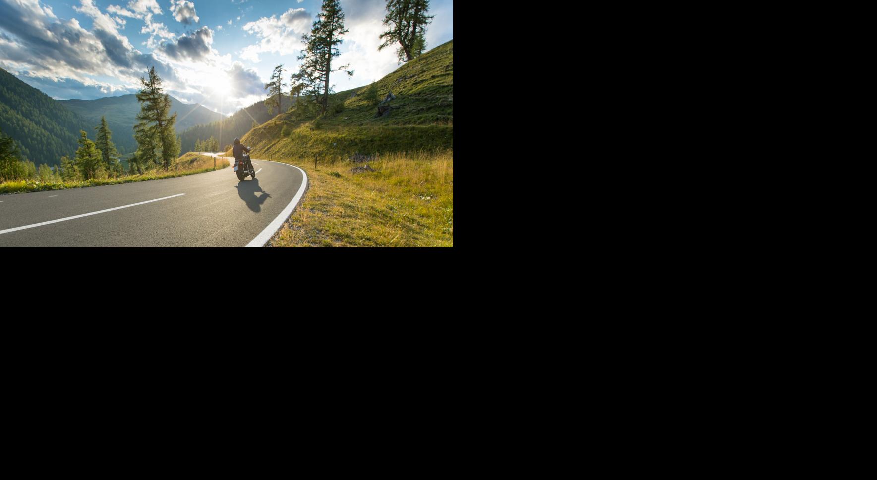 Motorcycle driver riding in Alpine highway, Nockalmstrasse, Austria, Europe.