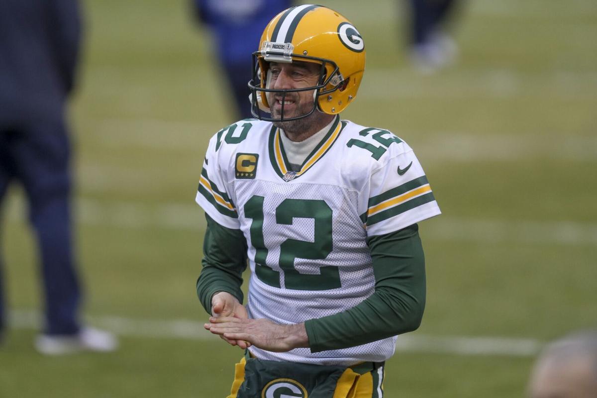 Packers quarterback Aaron Rodgers rubs grass on his hands while warming up.