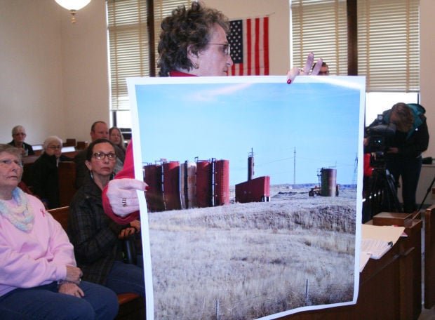 Nebraska resident holds photo of abandoned oil well