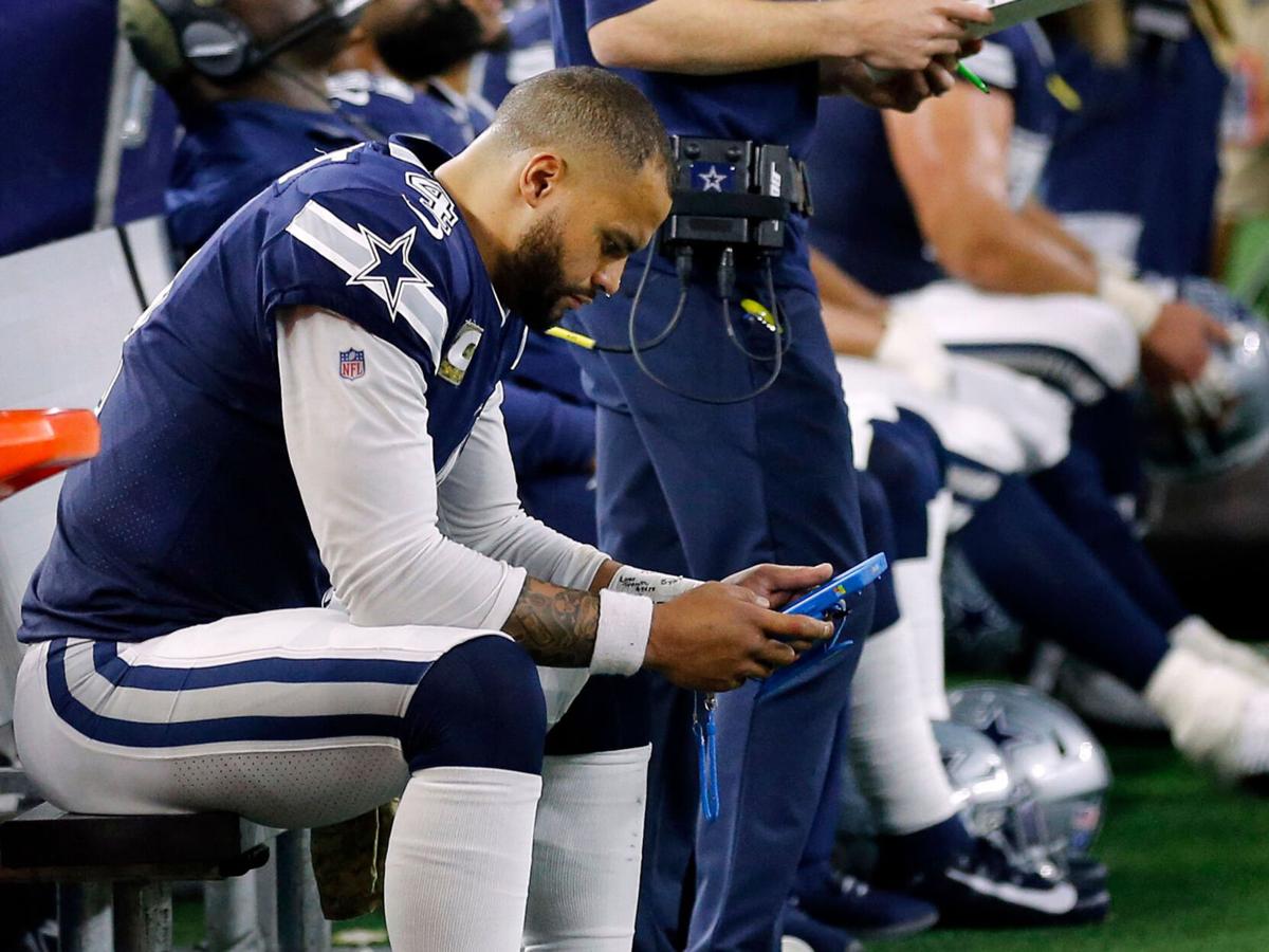 Dallas Cowboys quarterback Dak Prescott (4) looks at a tablet on the bench in the fourth quarter against the Minnesota Vikings at AT&T Stadium in Arlington, Texas, on November 10, 2019.