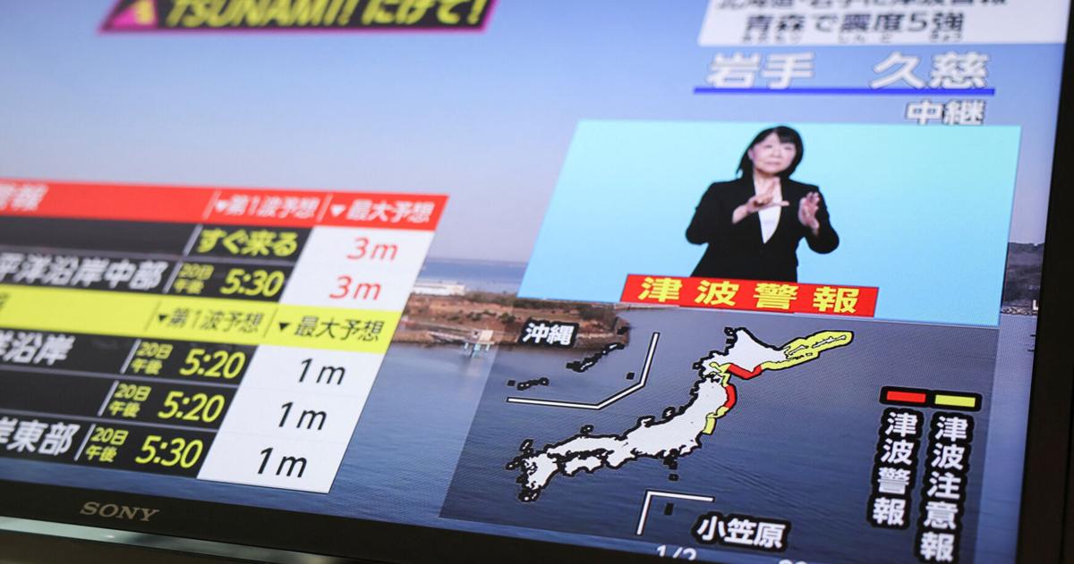 A television screen shows a news report on Japan Meteorological Agency's tsunami warning after an earthquake struck off the northeastern coast of Japan, in Tokyo