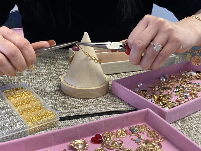 Frenchies Haus putting charms on a bracelet