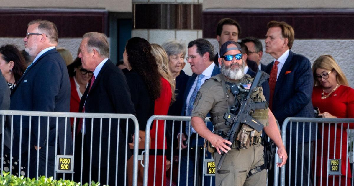 A PBSO SWAT team member stands guard as guests arrive to go through security before President Donald Trump speaks to the Forum