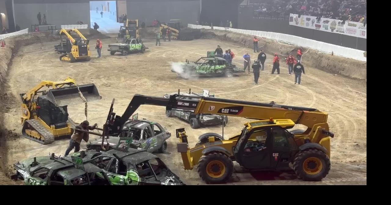 Heavy equipment works to remove derby cars from the track after the