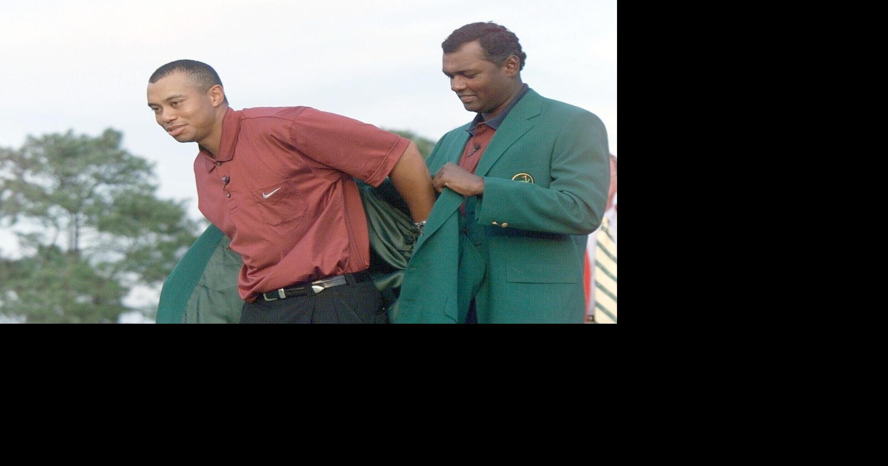 The 2000 Masters Champion, Vijay Singh, (r), helps the 2001 Masters Champion, Tiger Woods with the green jacket at the Masters