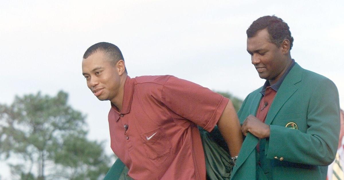 The 2000 Masters Champion, Vijay Singh, (r), helps the 2001 Masters Champion, Tiger Woods with the green jacket at the Masters