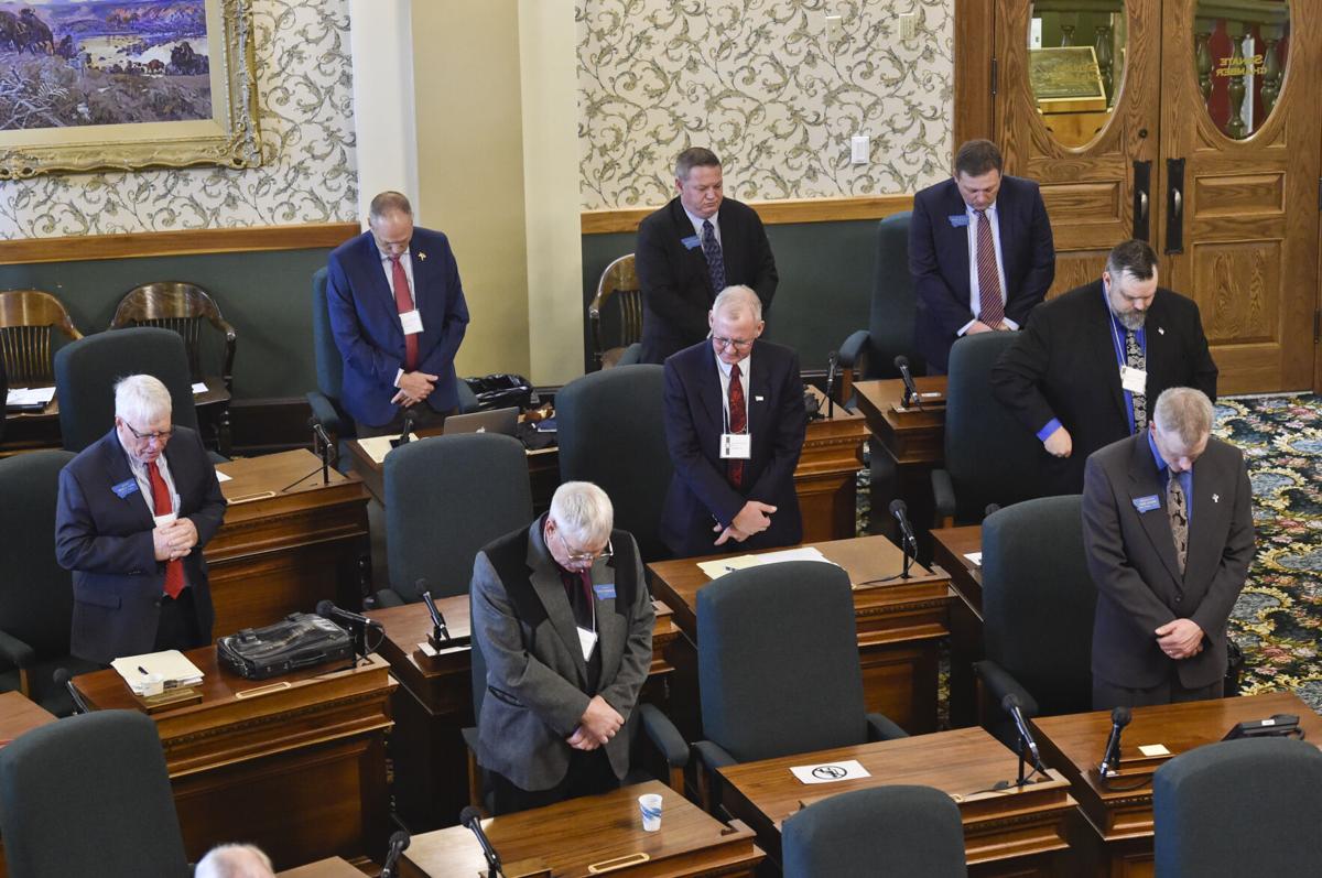 Maskless Republican senators bow there head's in prayer during Wednesday's caucus meeting.