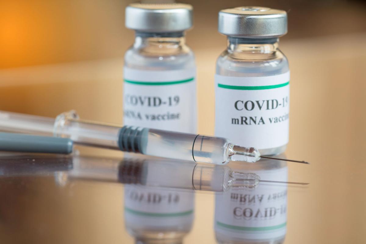 COVID-19 mRNA Vaccine and syringe with needle injection. Stock image