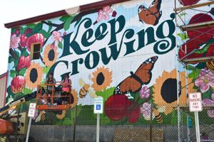 Photo illustrating article: Local artists put finishing touches on Clinton Cider Mill mural