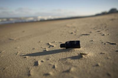 A small plastic bottle lies on the beach at the Virginia Beach oceanfront on Nov. 18, 2020.