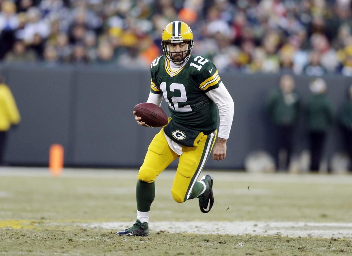 Green Bay Packers' Aaron Rodgers scrambles during the first half.