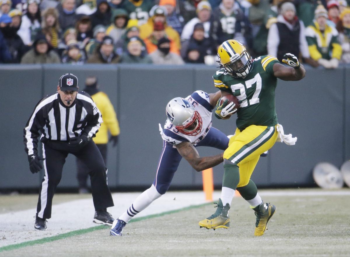 New England Patriots' Jonas Gray tackles Green Bay Packers' Eddie Lacy after a first down run in the first half.