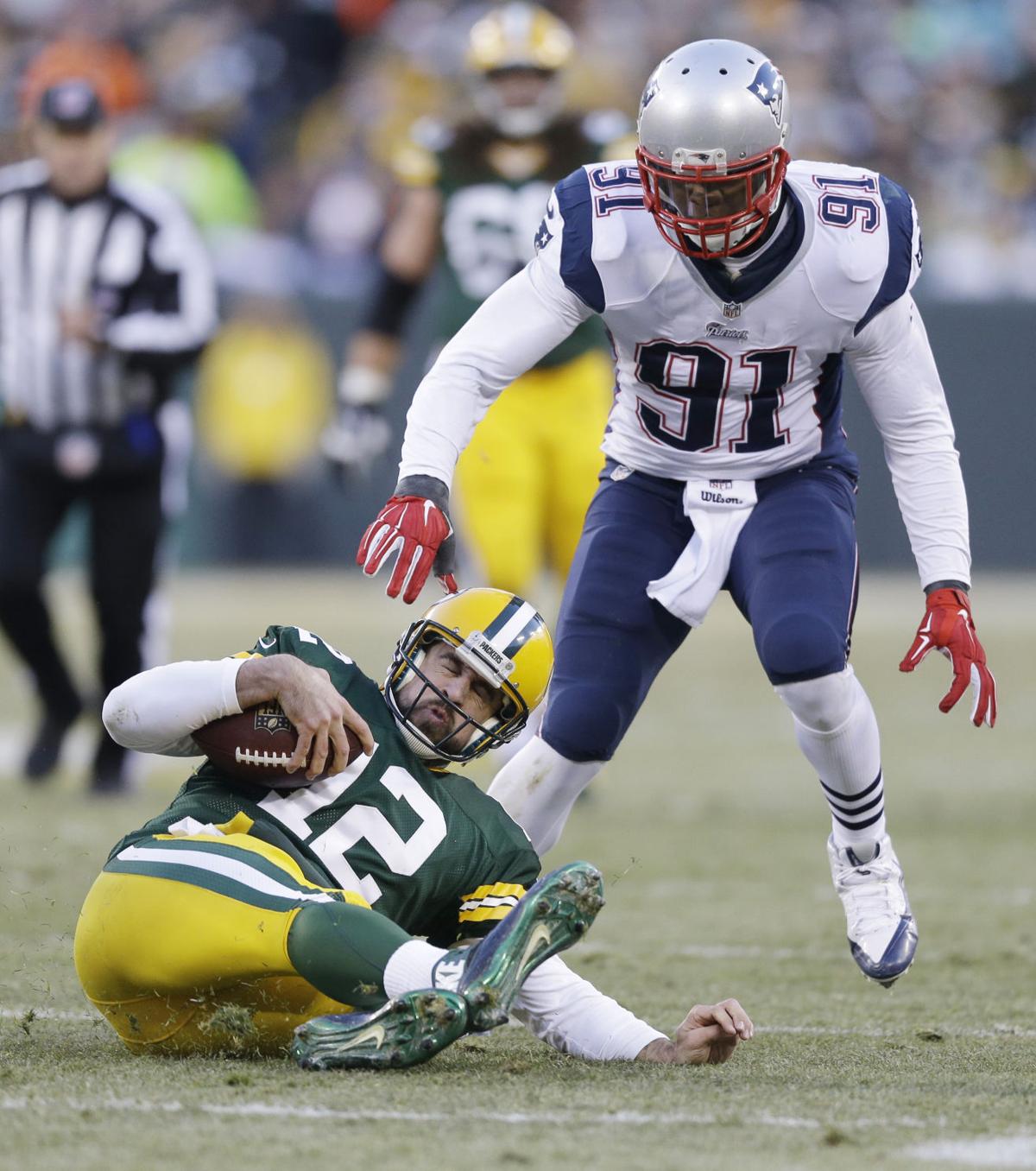 Green Bay Packers' Aaron Rodgers slides in front of New England Patriots' Jamie Collins (91) after a first down run during the first half.