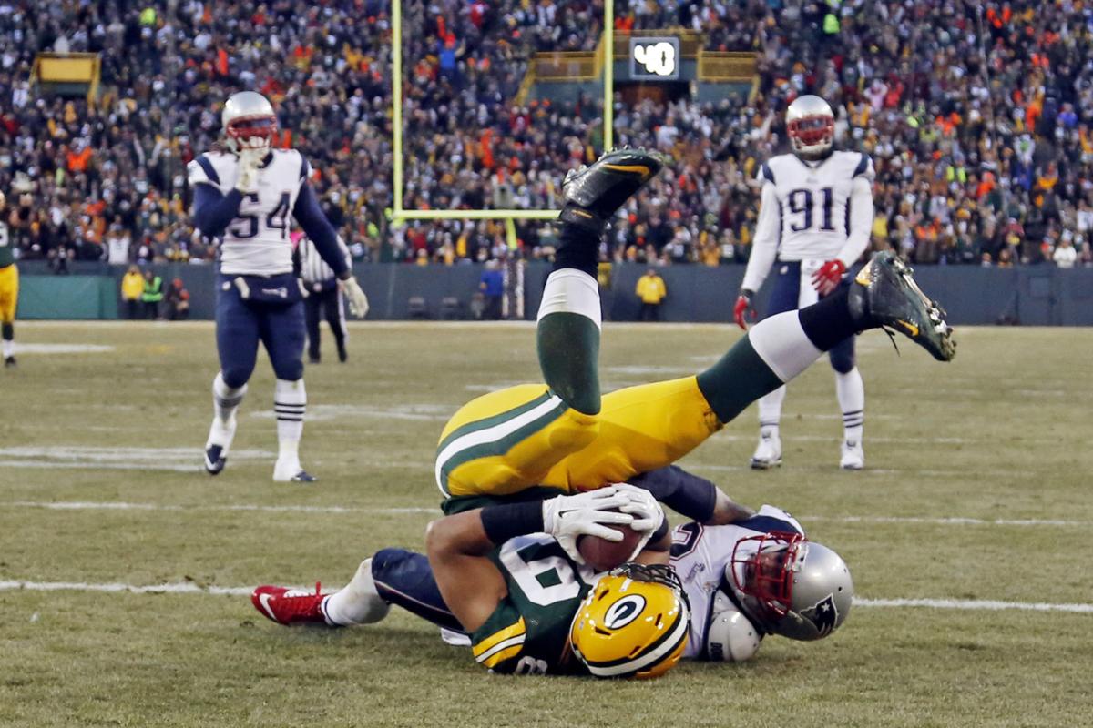 Green Bay Packers' Richard Rodgers catches a touchdown pass in front of New England Patriots' Patrick Chung during the first half.