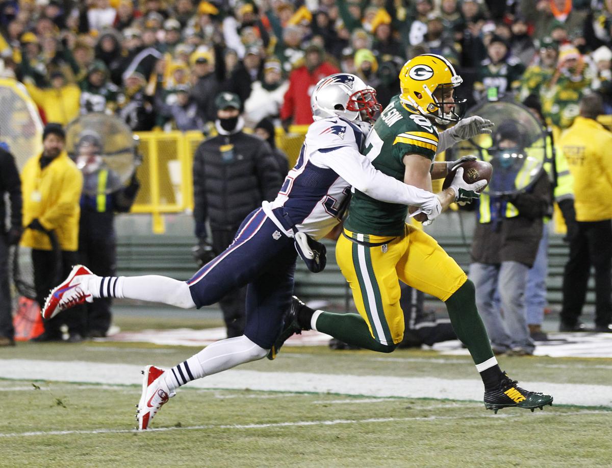 Green Bay Packers' Jordy Nelson scores a touchdown in front of New England Patriots' Devin McCourty after a catch during the first half.