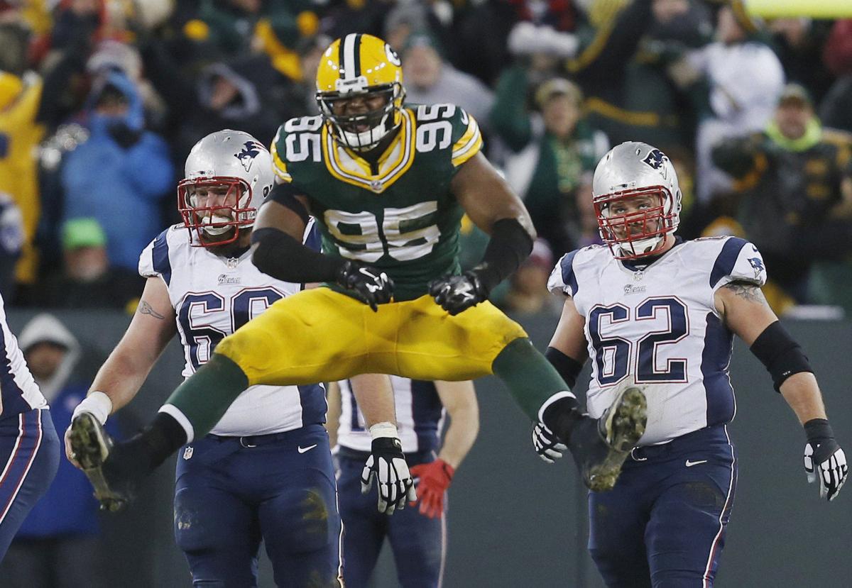 New England Patriots' Bryan Stork (66) and Ryan Wendell Wduring watch as Green Bay Packers' Datone Jones celebrates after Tom Brady was sacked in the second half.
