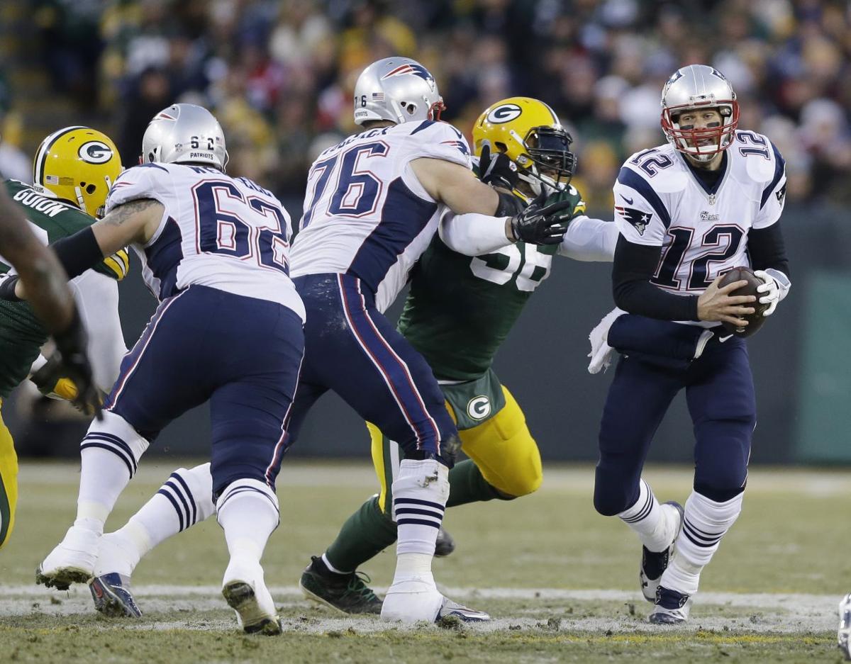 New England Patriots' Tom Brady scrambles during the first half.