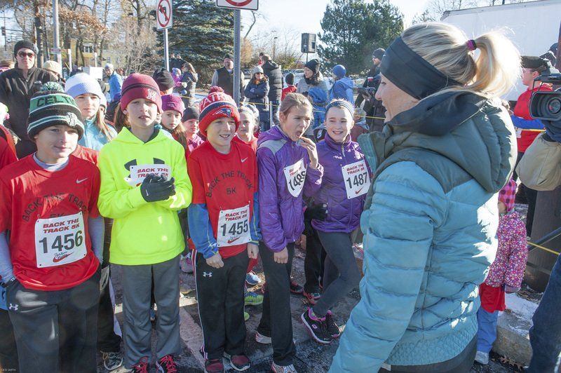 Shalane Flanagan encourages a group of runners before the start of the kids 1-mile race outside the Marblehead Community Center.