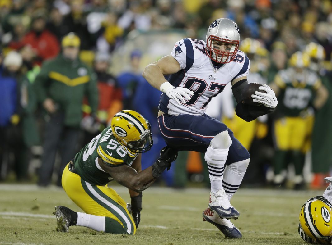 Green Bay Packers' Sam Barrington tries to stop New England Patriots' Rob Gronkowski during the first half.