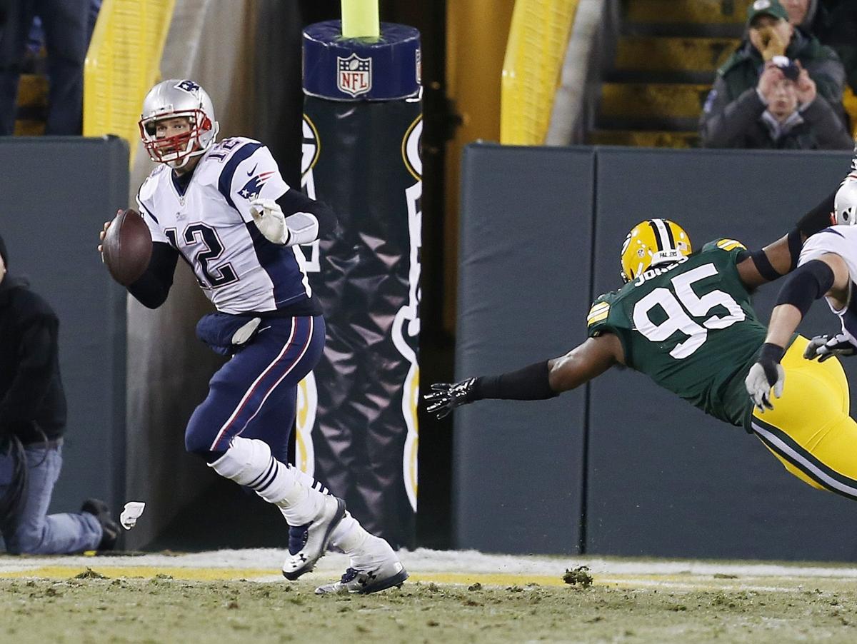 New England Patriots' Tom Brady scrambles away from Green Bay Packers' Datone Jones during the second half.