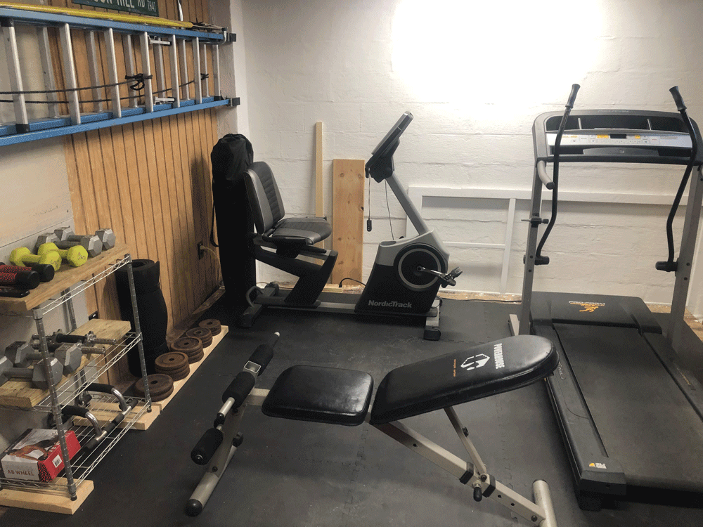 garage gym with treadmill, weight bench, and exercise bike