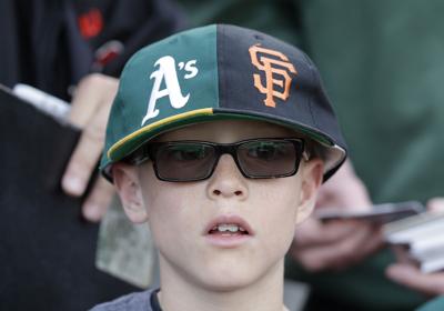 Fan with Athletics-Giants split hat