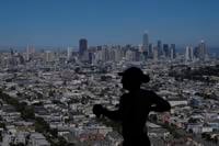Runner jogging past San Francisco skyline on Bernal Heights Hill
