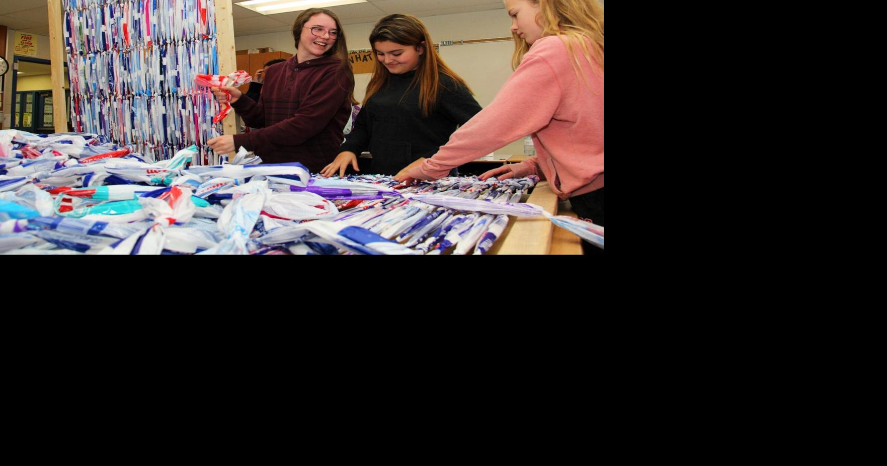 Students help the homeless by weaving milkbag mats in
