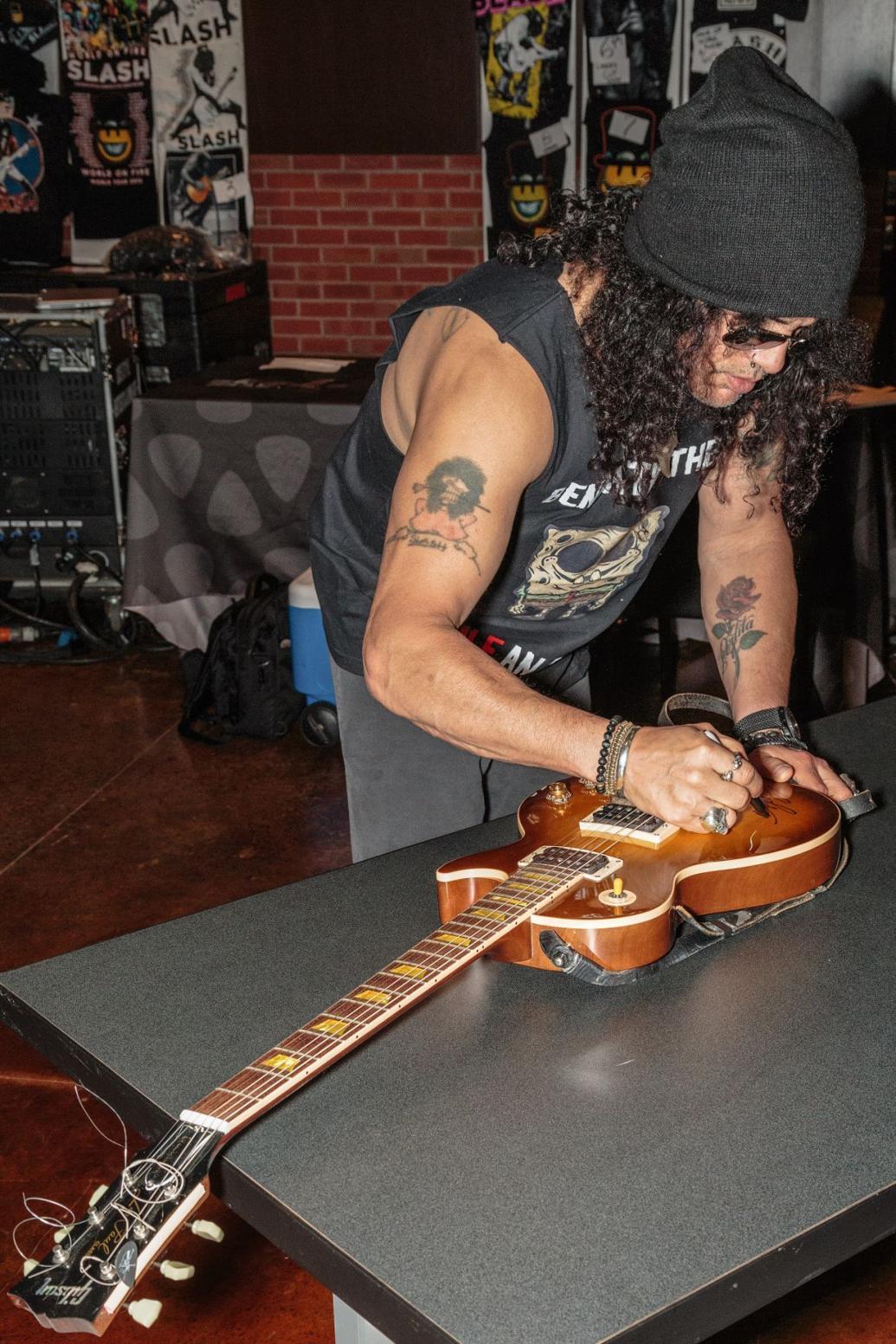 Slash autographs iconic guitar at Hard Rock