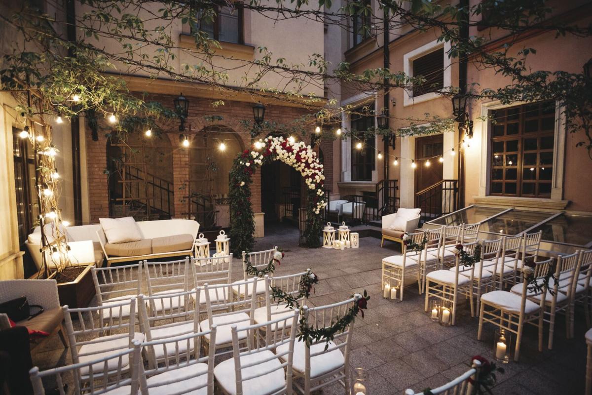 Red peonies and white hydrangeas pinned to the chairs before wedding altar