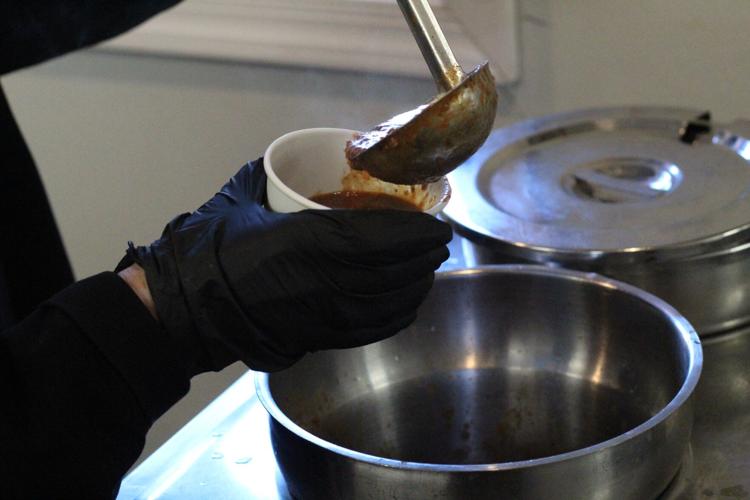 Market Street Pub employee putting soup on bowl for customer.