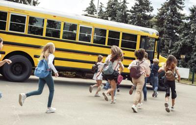 Classmates running to school bus back view late