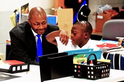 St. Louis Public Schools Superintendent Dr. Kelvin Adams is shown the days lesson by 4th grader Ronnie Gomiller during the first day of class Tues. Aug. 14, 2018. Photo by Wiley Price