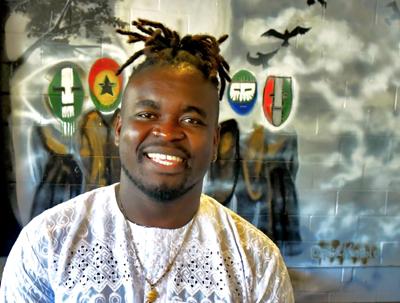 Brian Barlay is an African immigrant who just started his own business helping immigrants adapt to the culture of St. Louis. he sits in front of one of his paintings at the House of Jollof 503 in Florissant Wed July 13, 2022. Photo by Wiley Price / St. ...
