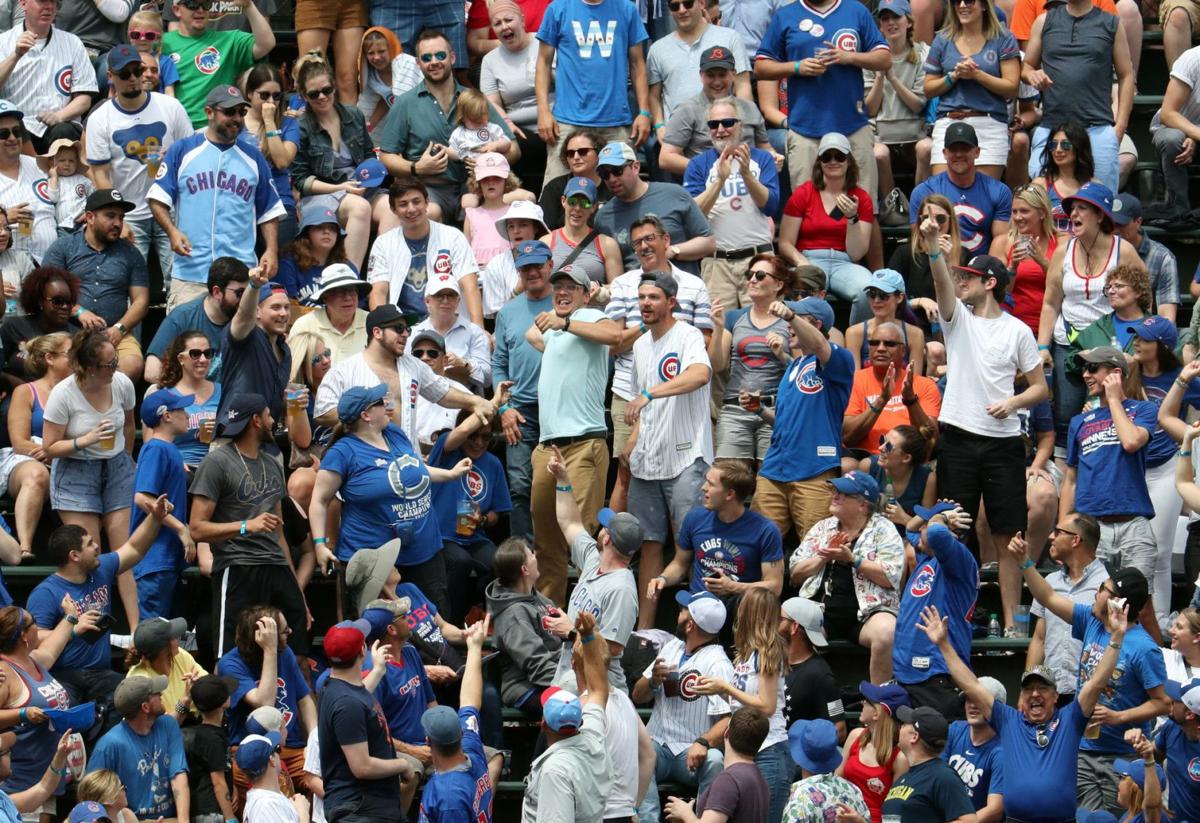 A Cubs fan in the Wrigley Field bleachers throws back a home run by Mets catcher Tomas Nido on June 23, 2019.