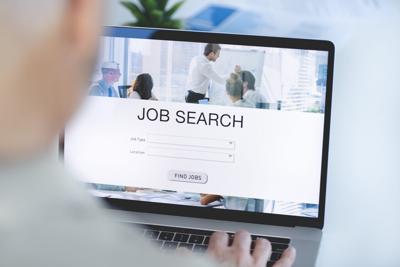 Mature Businessman looking at job search website on a laptop computer.