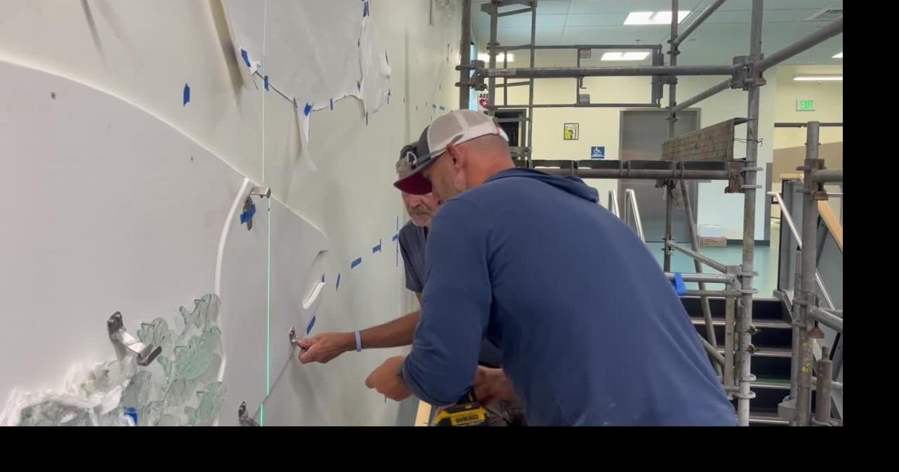 Workers install glass art at Lexington Elementary School