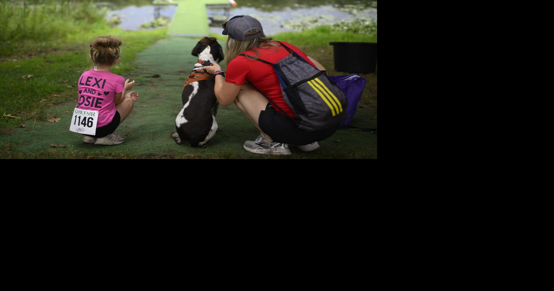 Lexi Loge, 6, her Springer Spaniel, Rosie, and mother Lisa, from Glenwood City, Wisconsin, prepare to release Rosie for a retrieving activity on Aug. 7, 2026, at Game Fair in Ramsey, Minnesota.