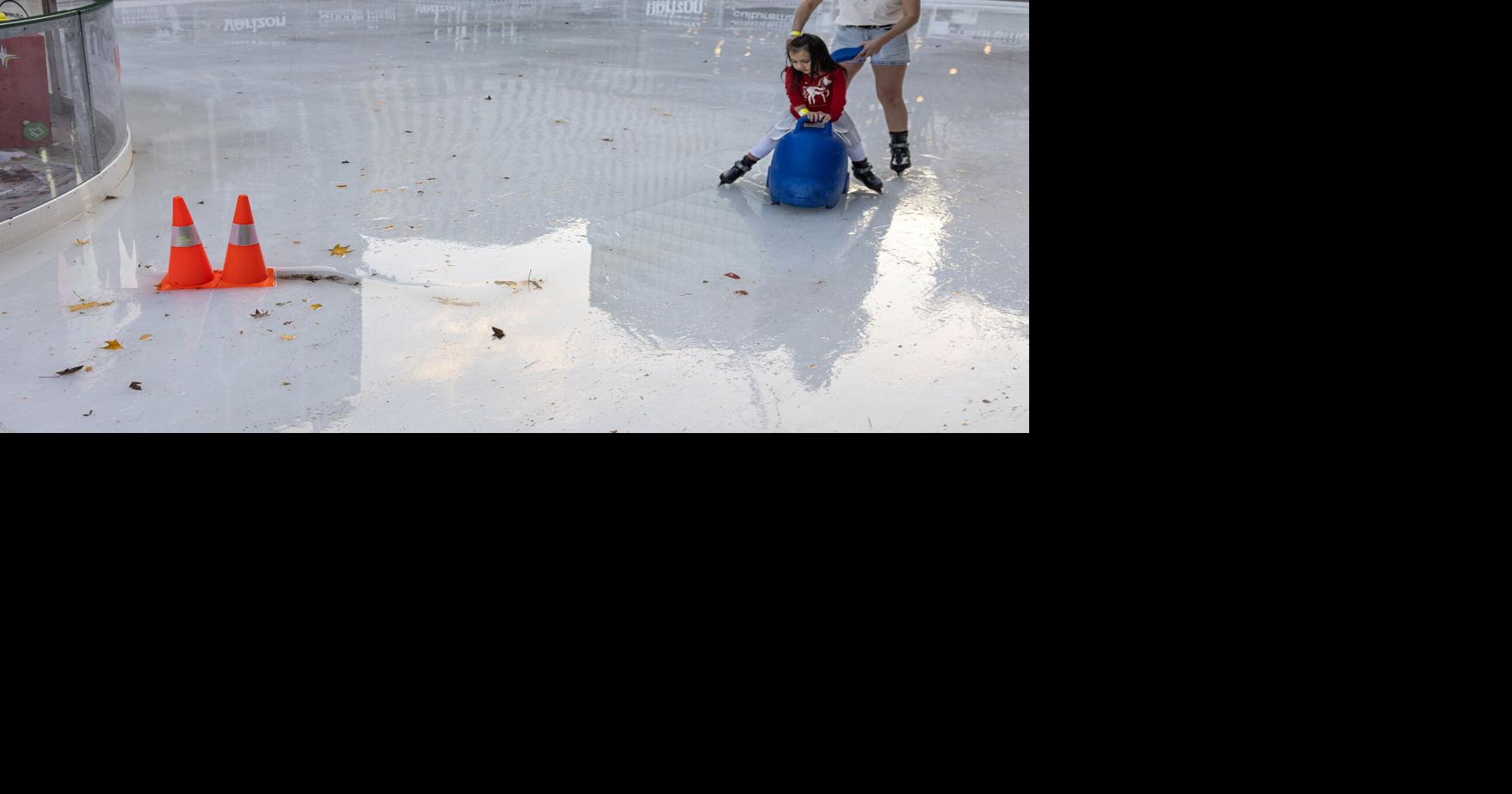 Arisbet Cantu pushes daughter Yhnai around a partially melted ice rink on a warm Tuesday evening, Dec. 23, 2025, in downtown Dallas.