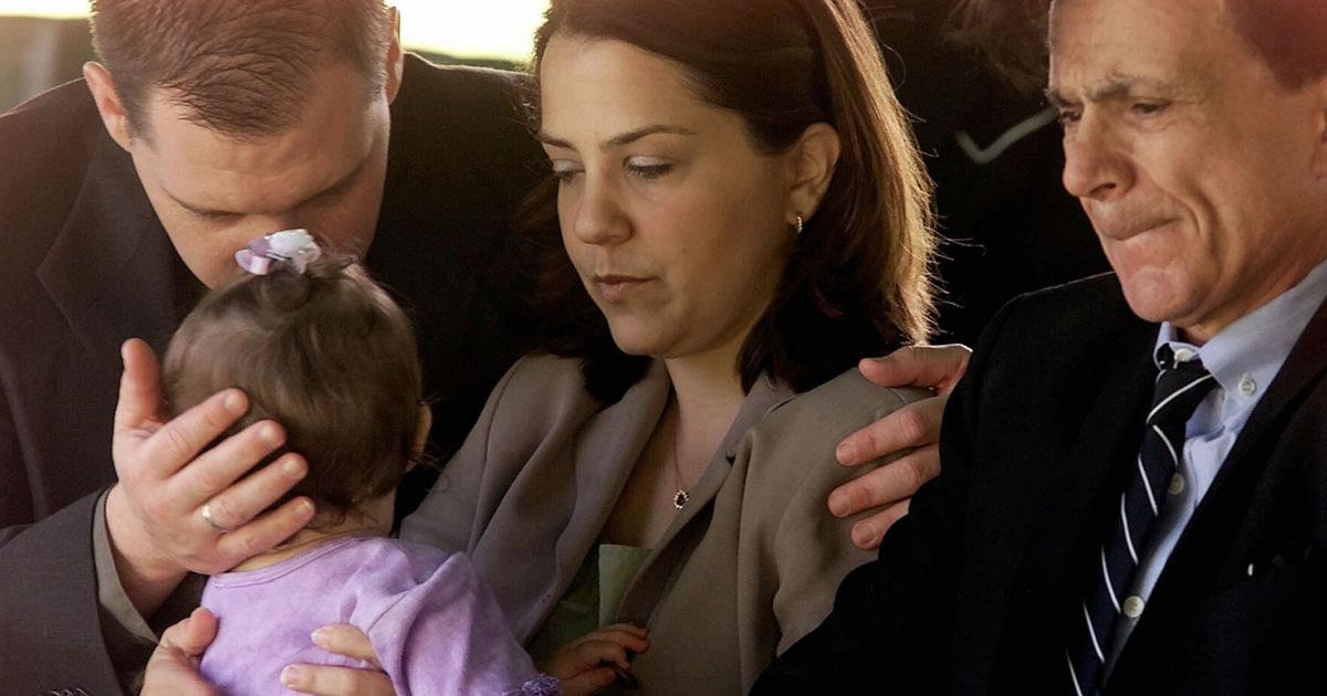 Actor Robert Blake, grimaces as his daugther, Delina Blake, holds his 11- month-old daughter, Rose Lenore Sophie Blake, as they arrive at the grave site of her slain mother, Bonny Lee Bakley, during a brief funeral ceremony in Los Angeles on May 25, 2001.