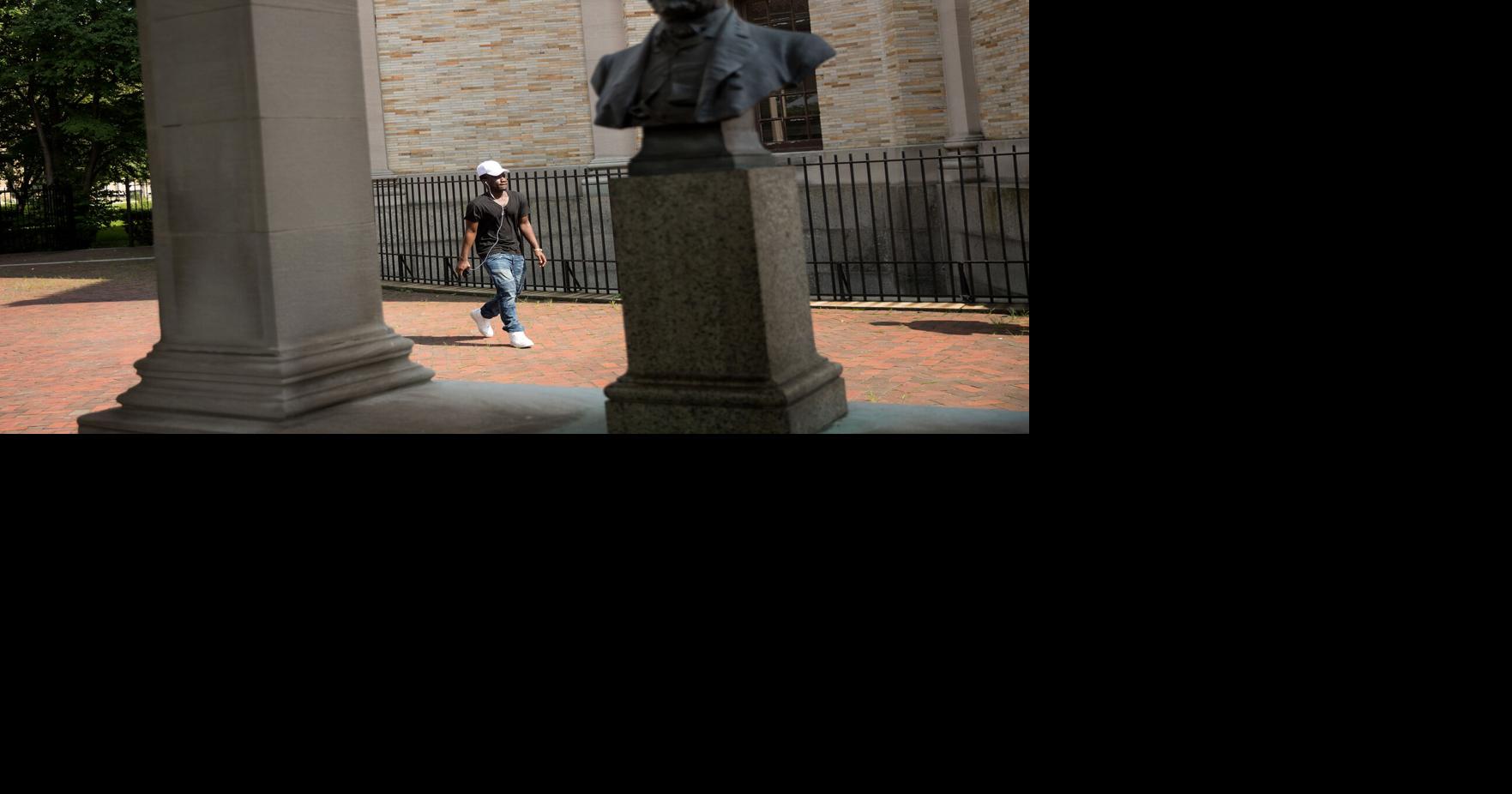 A man walks past a bust of Robert E. Lee as it stands in the' Hall of Fame for Great Americans' on the campus of Bronx Community College, Aug. 17, 2017, in the Bronx borough of New York City.