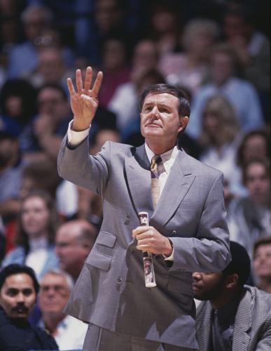 Denny Crum, head coach for the University of Louisville Cardinals, gives hand signals to pass on instructions to his players during the NCAA Pac-10 Conference college basketball game against the UCLA Bruins on March 6, 1994 at the Pauley Pavillion, West...