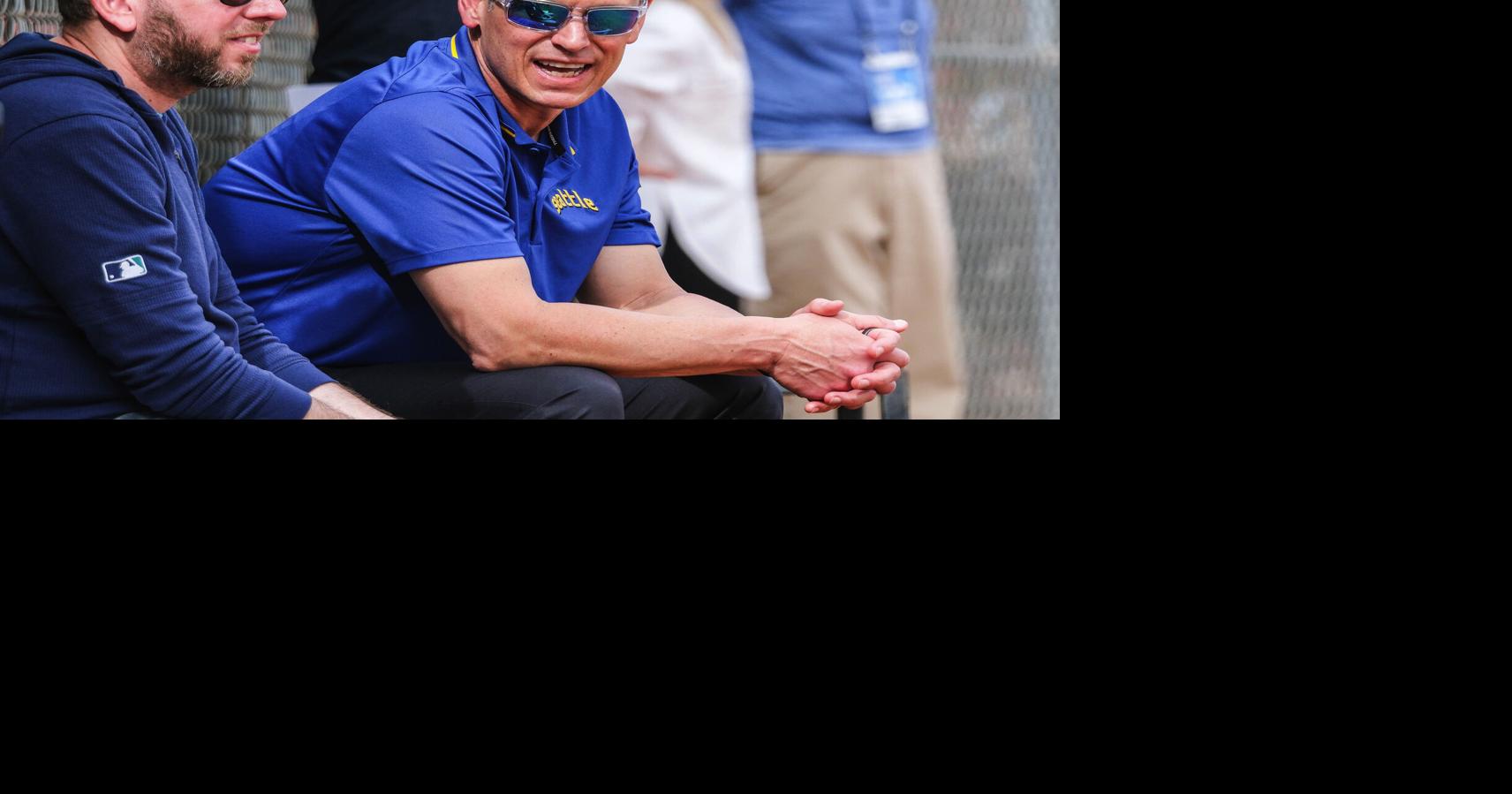 Seattle Mariners front office executives Justin Hollander, left, and Jerry Dipoto take in batting practice during a spring training game on Feb. 25, 2024, at the Peoria Sports Complex in Peoria, Arizona.