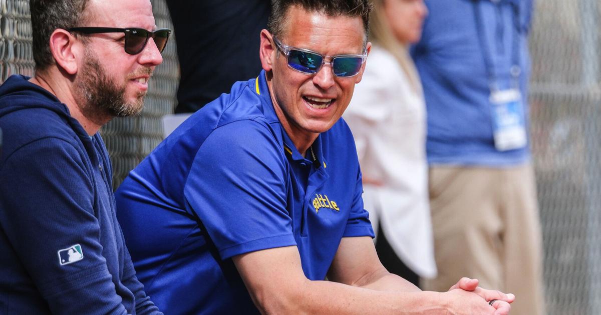 Seattle Mariners front office executives Justin Hollander, left, and Jerry Dipoto take in batting practice during a spring training game on Feb. 25, 2024, at the Peoria Sports Complex in Peoria, Arizona.