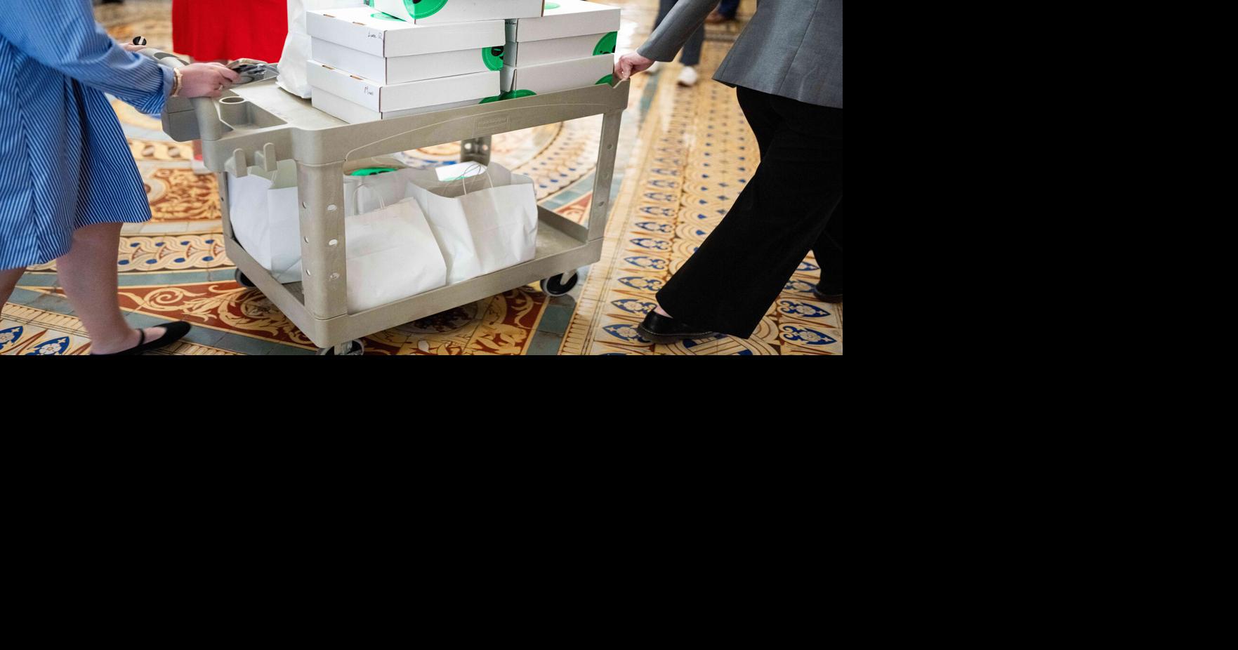 Staffers transport food for Republican Senators through the Ohio Clock Corridor to the Strom Thurmond room during the Senate's vote-a-rama on Thursday, June 4, 2026.