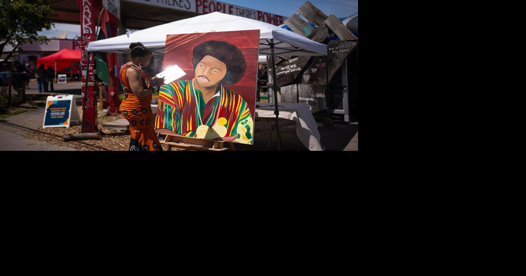 Noval Noir with her painting of the Rev. Jesse Jackson at George Floyd Square in Minneapolis.
