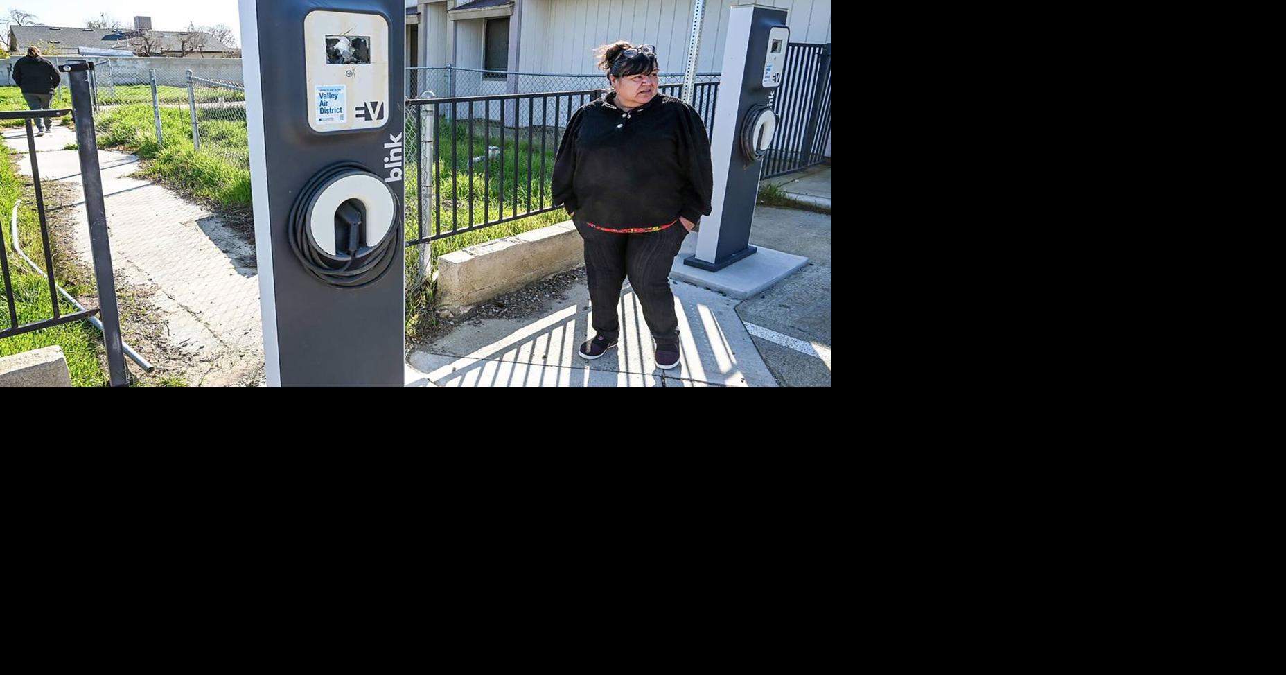 Cantua Creek resident Blanca Gomez stands by a pair of vandalized EV