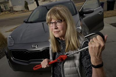 Debbie McClung holds a Club Steering Wheel Lock for her 2017 Kia Sportage at her home in Denver on Tuesday, March 14, 2023.