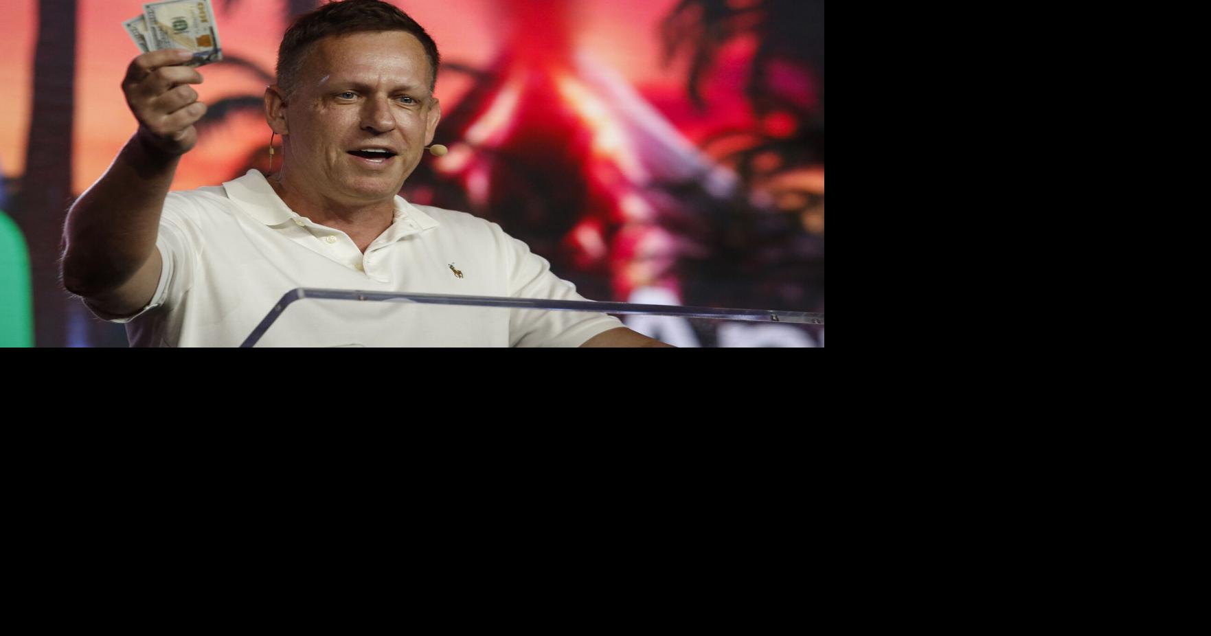 Peter Thiel, co-founder of PayPal, Palantir Technologies, and Founders Fund, holds hundred dollar bills as he speaks during the Bitcoin 2022 Conference at Miami Beach Convention Center on April 7, 2022, in Miami.