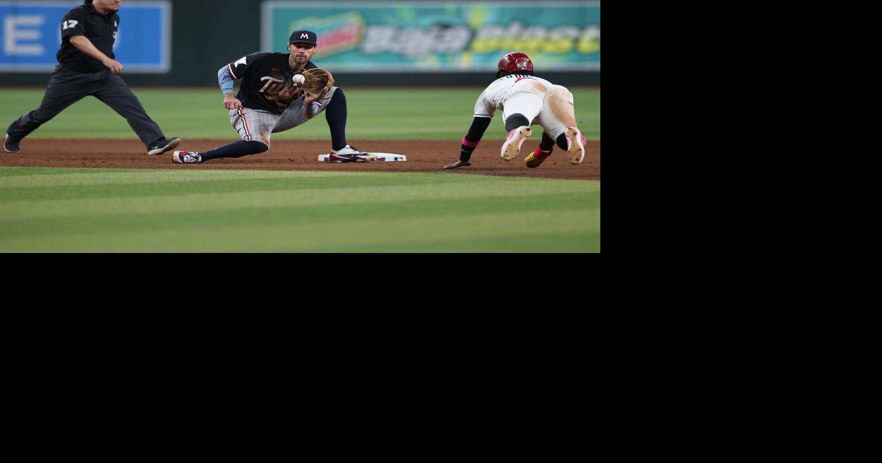 Ryan Kreidler of the Minnesota Twins fields the ball as Geraldo Perdomo of the Arizona Diamondbacks tries to steal second base during the seventh inning of the MLB game at Chase Field on Sunday, June 21, 2026, in Phoenix.